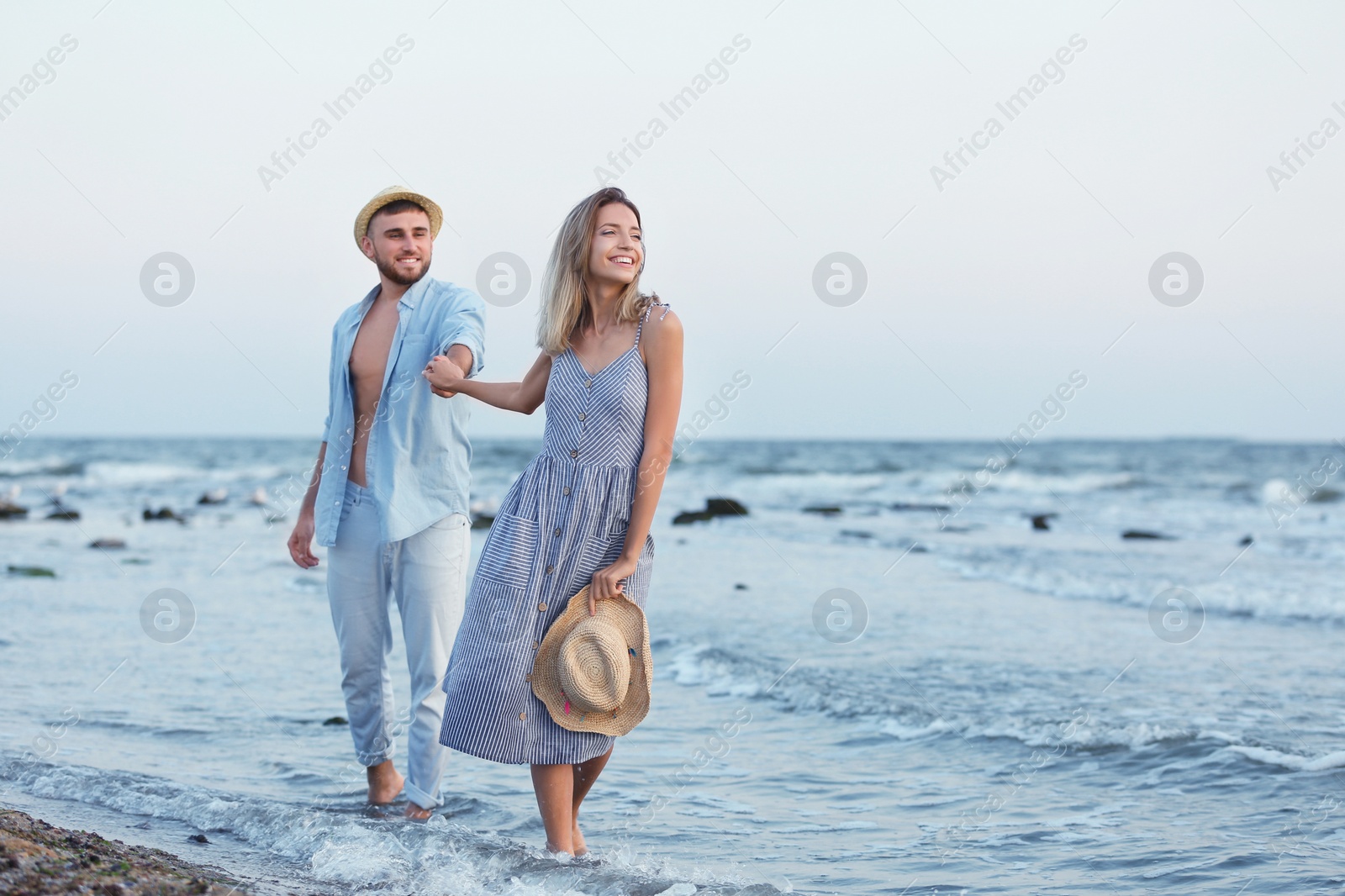 Photo of Young couple spending time together on beach