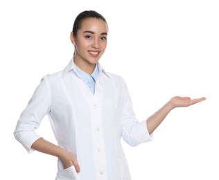 Photo of Beautiful young doctor showing something on white background