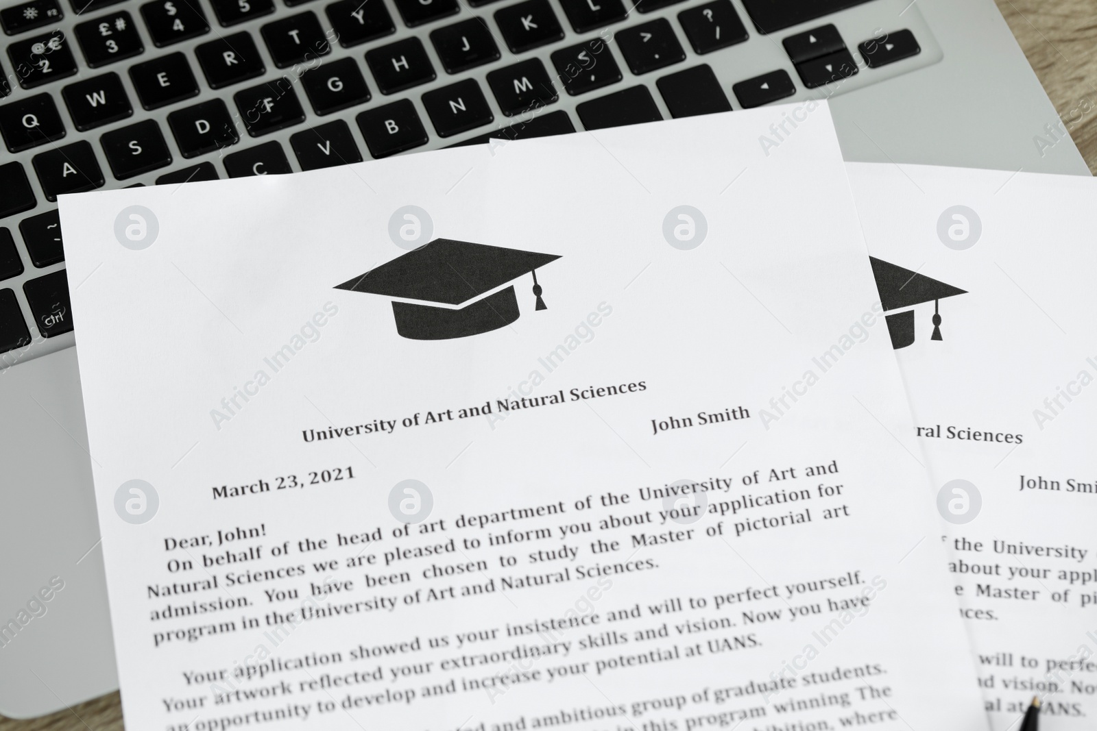 Photo of Acceptance letters from universities and laptop on wooden table indoors, closeup