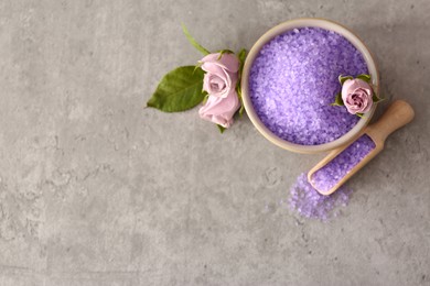 Photo of Purple sea salt and beautiful flowers on light grey table, flat lay. Space for text