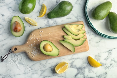 Photo of Flat lay composition with ripe avocados and lemon on marble background