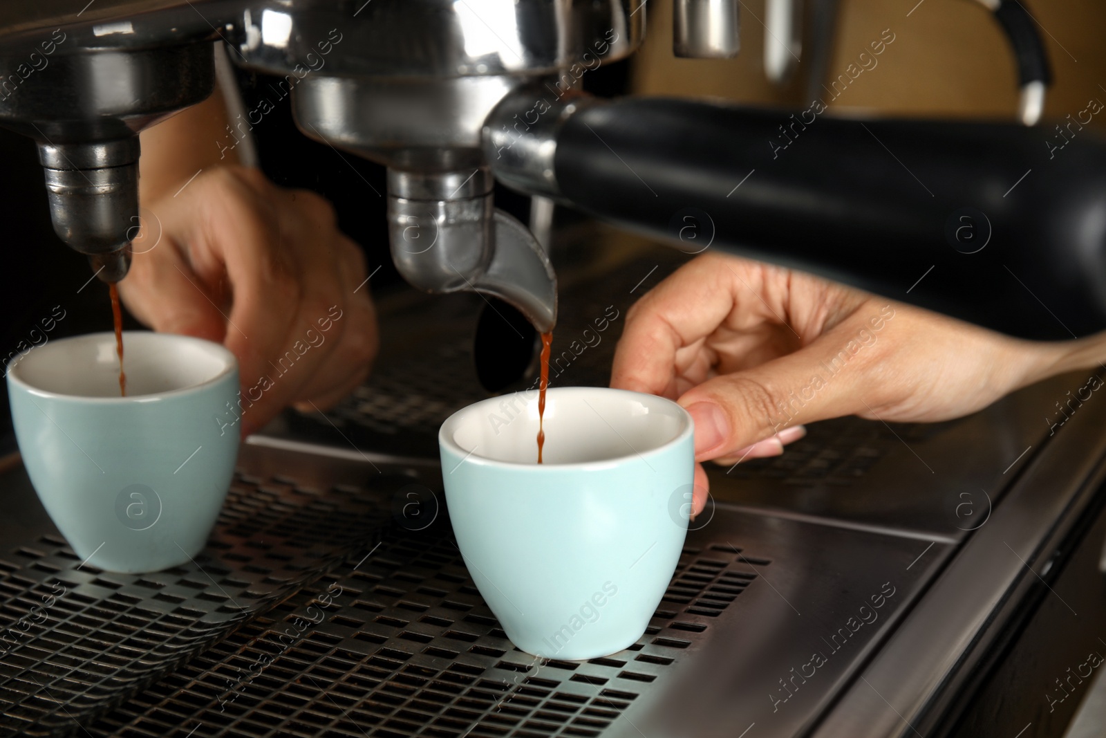 Photo of Barista making espresso using professional coffee machine, closeup