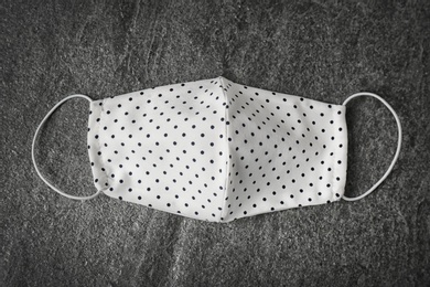 Photo of Homemade protective face mask on grey stone table, top view