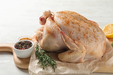 Photo of Board with raw spiced turkey and ingredients on table