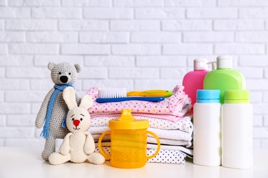 Baby accessories on table near white brick wall