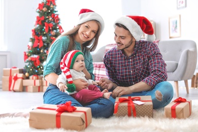 Happy couple with baby celebrating Christmas together at home