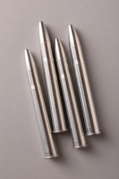 Many metal bullets on light grey background, flat lay