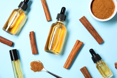 Photo of Flat lay composition with cinnamon essential oil on blue background