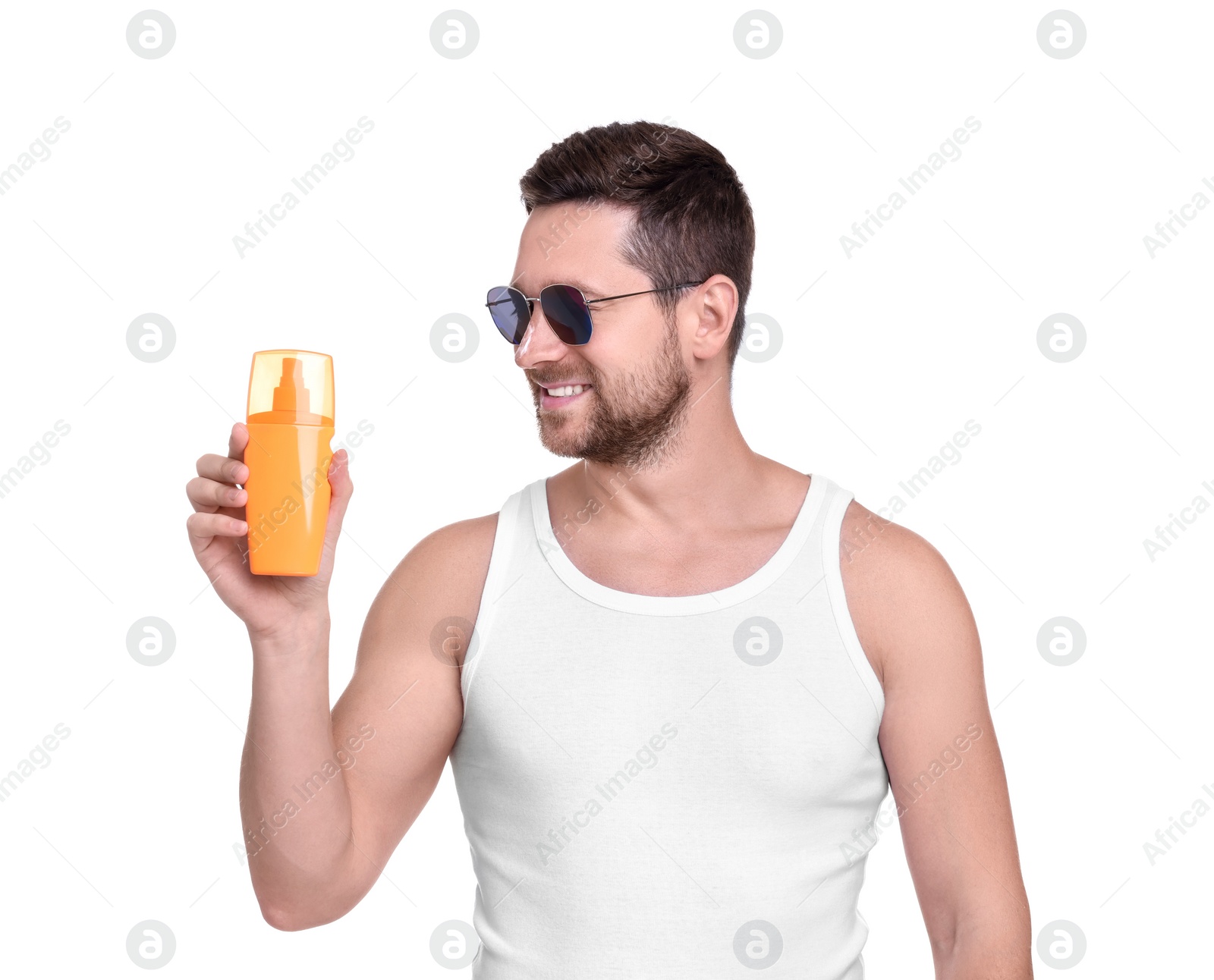 Photo of Handsome man in sunglasses holding bottle of sun protection cream on white background