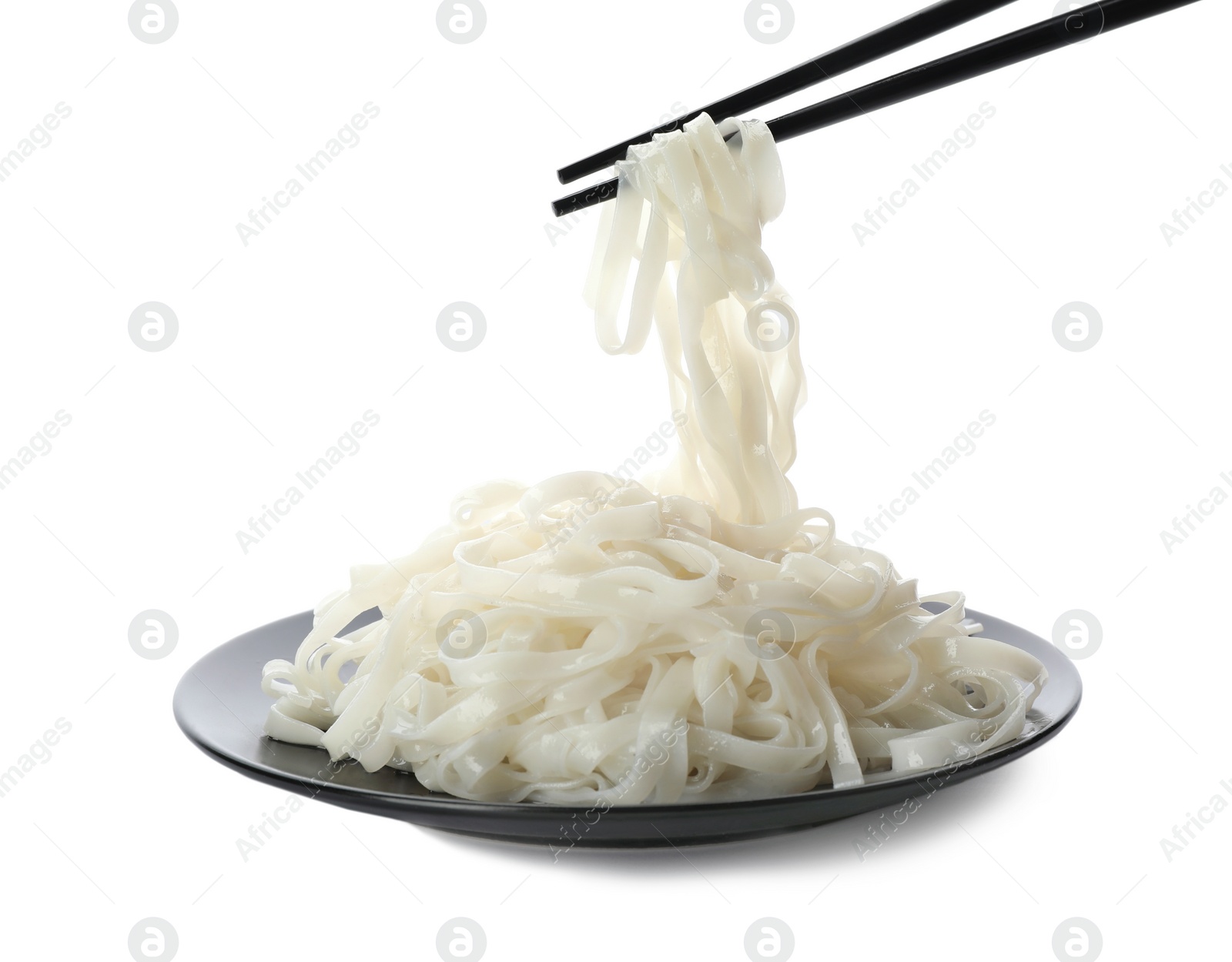 Photo of Taking rice noodles with chopsticks from plate on white background