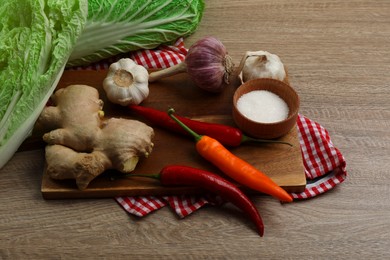 Photo of Fresh Chinese cabbages and ingredients on wooden table