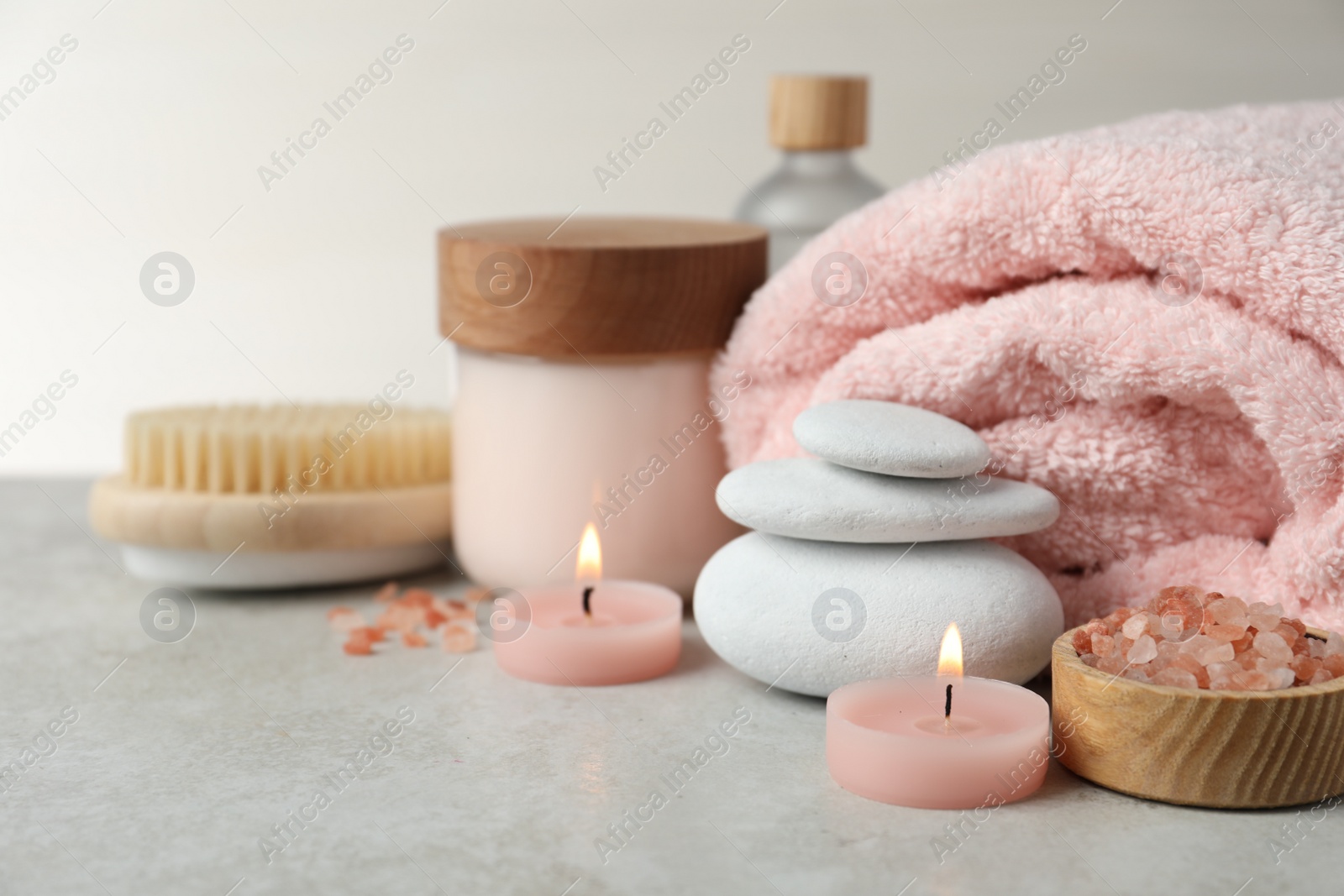 Photo of Beautiful composition with burning candles and different spa products on light grey table