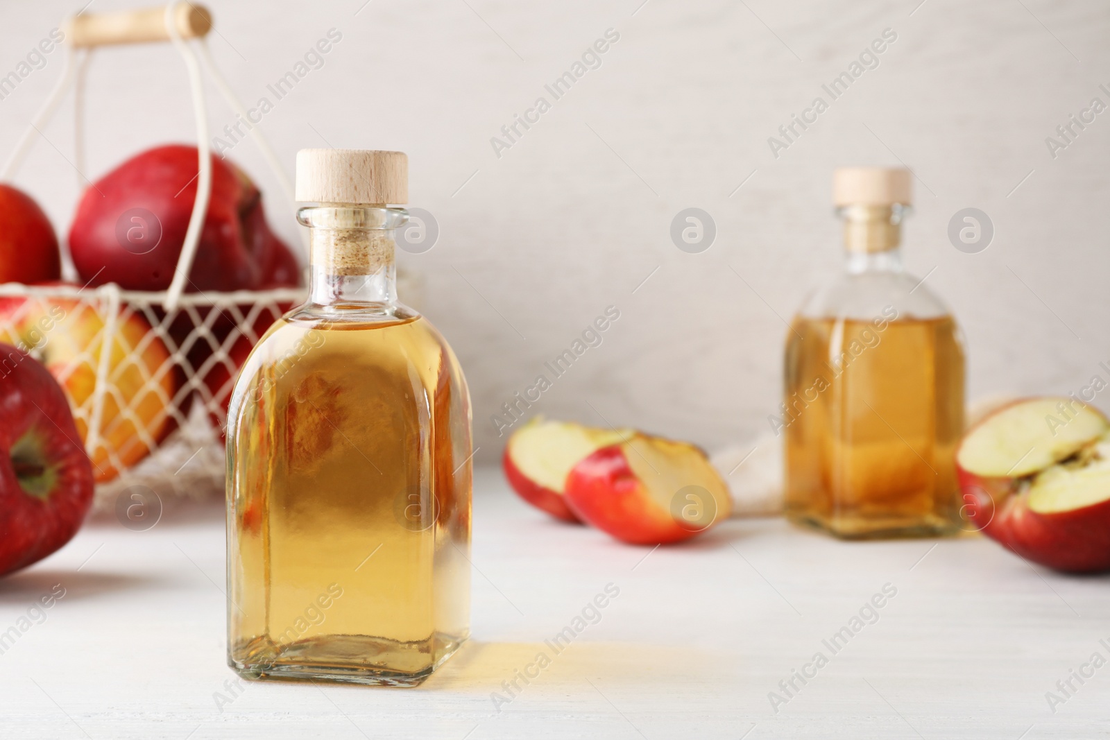 Photo of Composition with bottle of apple vinegar on table. Space for text