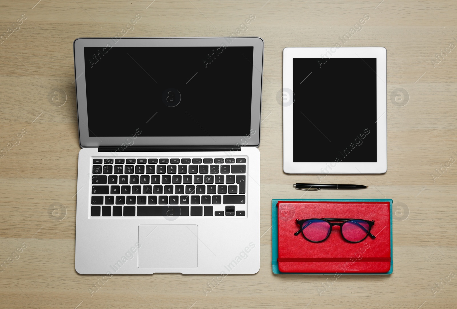 Photo of Modern gadgets, glasses and office stationery on wooden table, flat lay. Distance learning