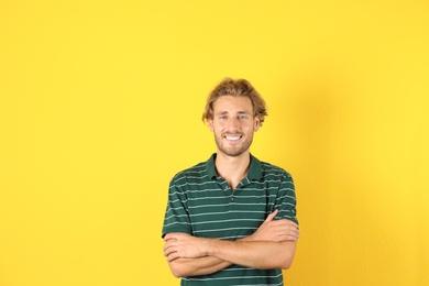 Photo of Handsome young man laughing on color background