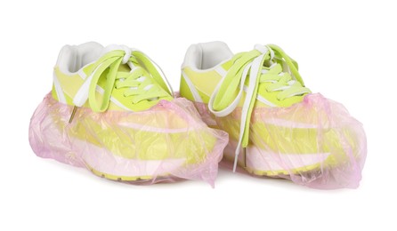 Sneakers in pink shoe covers isolated on white