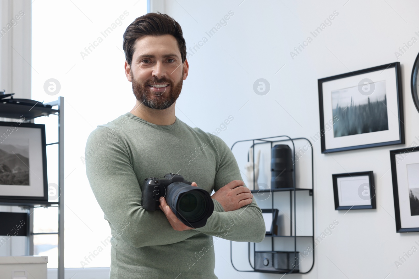 Photo of Professional photographer with digital camera indoors, space for text