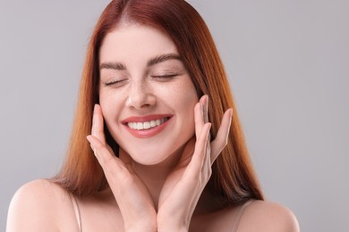 Portrait of smiling woman on grey background, closeup