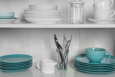 Photo of White shelving unit with set of dishware