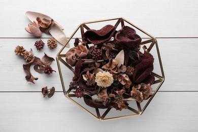 Photo of Aromatic potpourri of dried flowers in bowl on white wooden table, flat lay