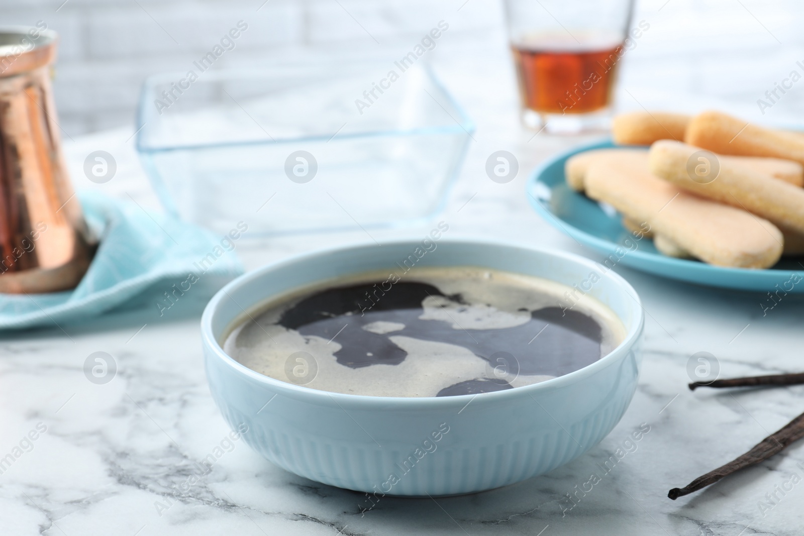 Photo of Bowl of coffee for tiramisu cake on white marble table