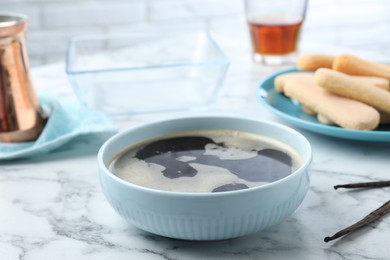 Bowl of coffee for tiramisu cake on white marble table