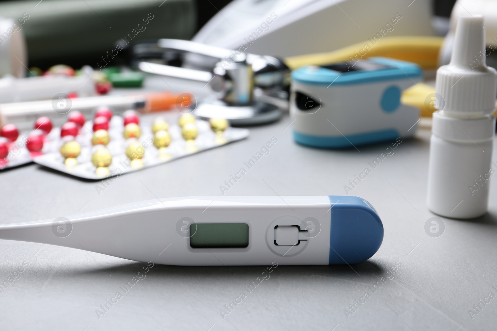 Photo of Thermometer and other medical objects on grey table