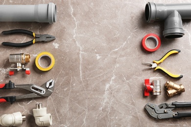 Photo of Flat lay composition with plumber's tools and space for text on grunge background