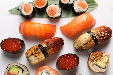 Photo of Different tasty sushi rolls on white background, flat lay