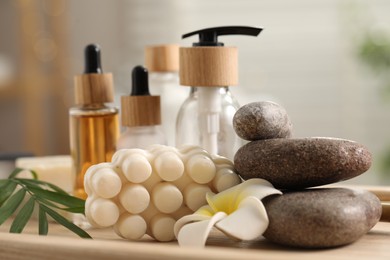 Composition with different spa products and plumeria flower on tray, closeup