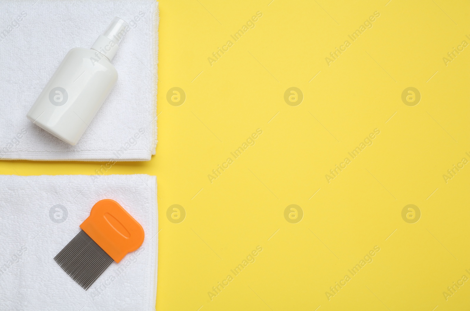 Photo of Comb, anti lice spray and towels on yellow background, flat lay. Space for text
