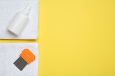 Photo of Comb, anti lice spray and towels on yellow background, flat lay. Space for text