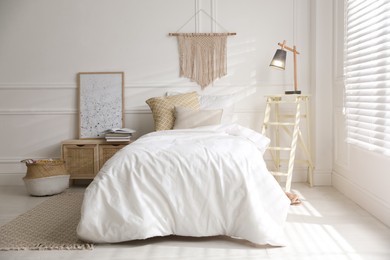 Comfortable bed with clean white linens indoors