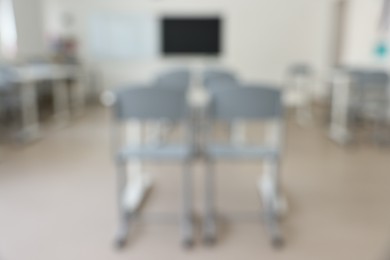 Blurred view of empty school classroom with desks and chairs