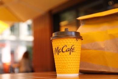 MYKOLAIV, UKRAINE - AUGUST 11, 2021: Hot McDonald's drink and packed food on table in cafe. Space for text