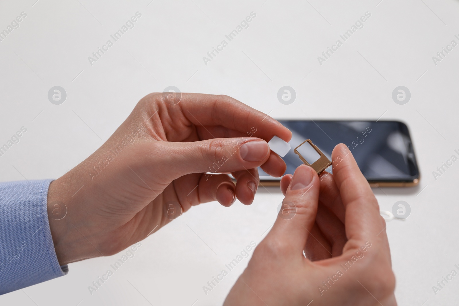 Photo of Woman with SIM card and slot tray on white background, closeup
