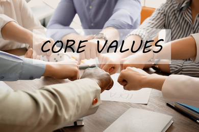 Core values concept. People putting hands together at table, closeup