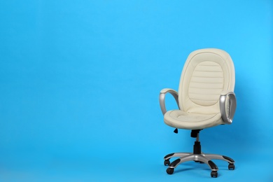 Photo of Comfortable office chair on light blue background, space for text