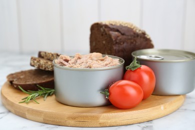 Photo of Composition with canned tuna on white marble table, closeup