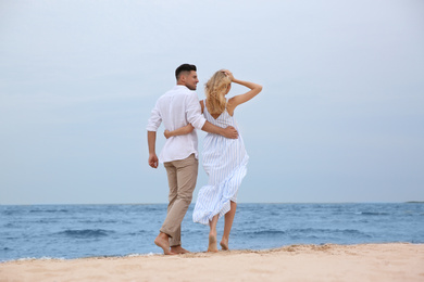 Photo of Happy couple having romantic walk on beach