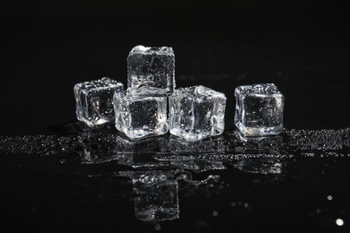 Photo of Pile of crystal clear ice cubes on black background