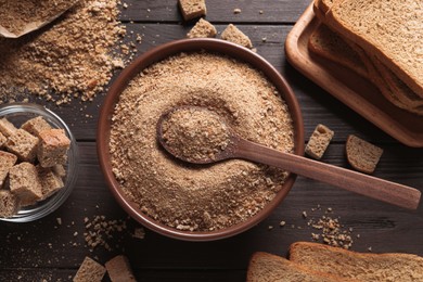 Photo of Fresh breadcrumbs and spoon on wooden table, flat lay