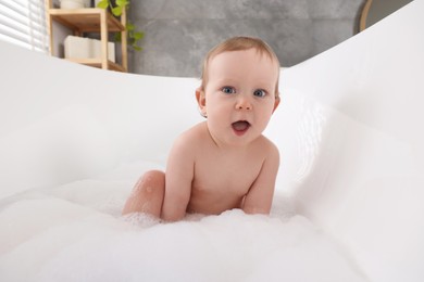 Photo of Cute little baby bathing in tub at home