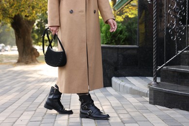Photo of Fashionable woman with stylish bag on city street, closeup