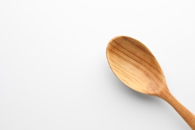 Photo of One wooden spoon on white background, top view. Space for text