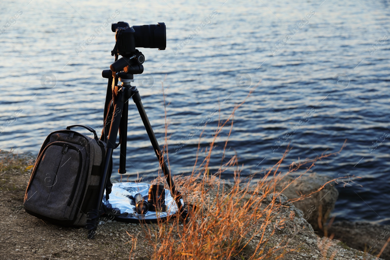 Professional photography equipment on rocky river coast Photo of Professional photography equipment on rocky river coast