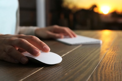 Photo of Woman using computer mouse and keyboard at table, closeup