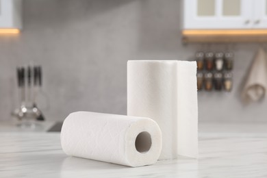 Photo of Rolls of paper towels on white marble table in kitchen