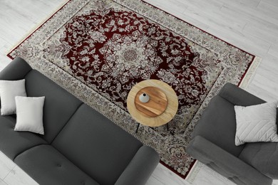 Photo of Cozy room interior with stylish furniture and soft carpet with beautiful pattern, view from above
