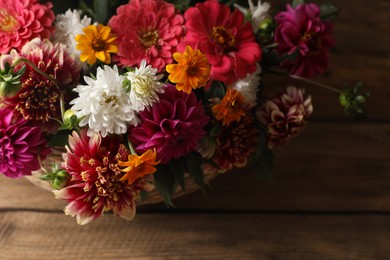 Photo of Beautiful wild flowers and leaves on wooden table, above view